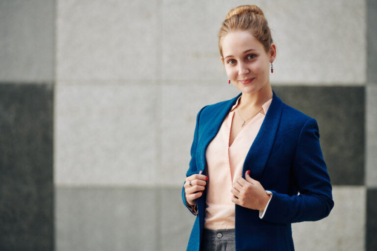 Une belle femme portant un blazer bleu avec une chemise rose décolletée