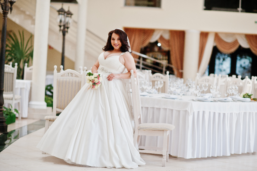 Une femme qui porte une robe de mariée idéale pour sa taille ronde