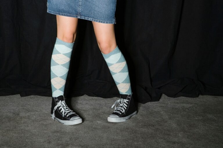 Femme portant des chaussettes hautes avec une jupe plissée