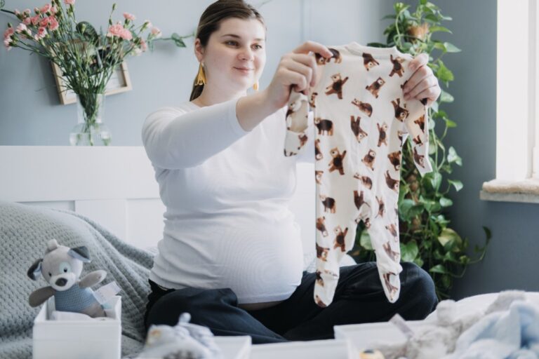 Une femme enceinte choisissant le vêtement à mettre dans sa liste de naissance