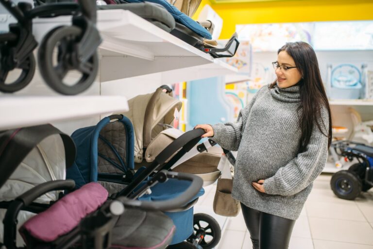 Une femme enceinte qui choisie une poussette dans un magasin