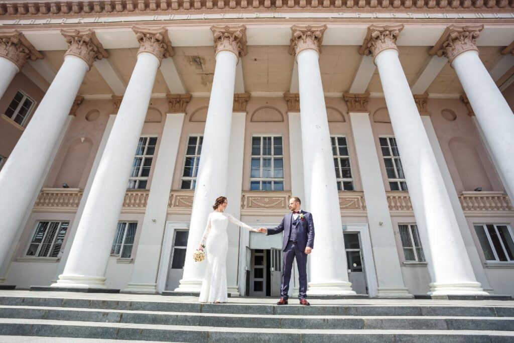 Un couple devant une mairie après leur célébration de mariage