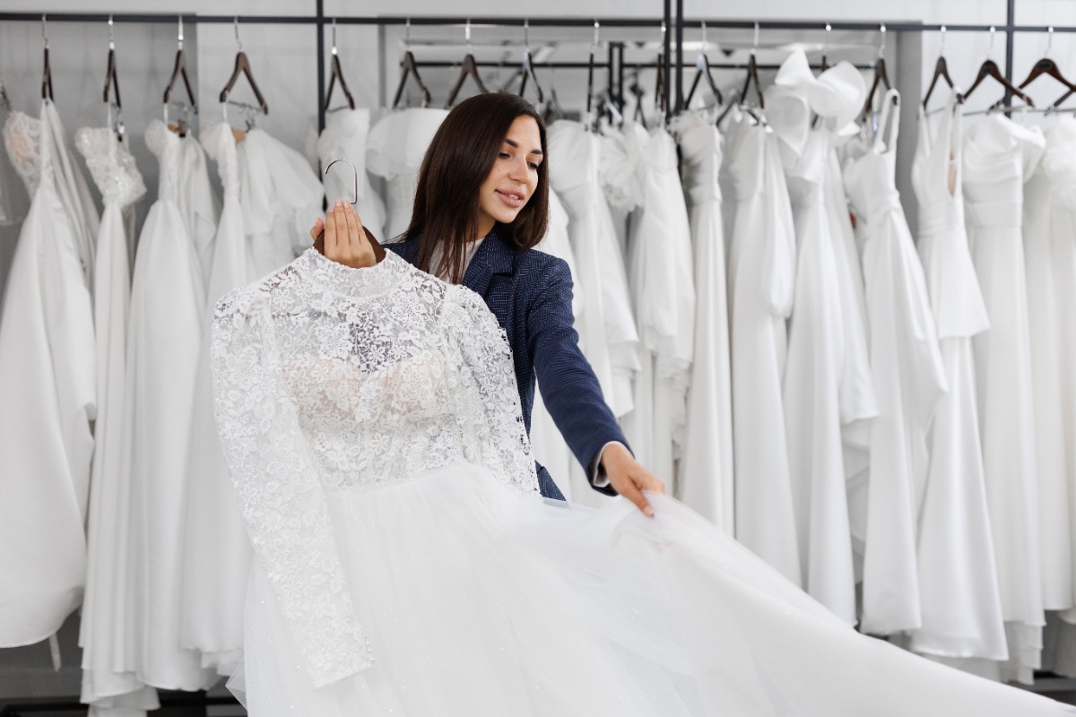 Une femme qui choisi une robe de mariée dans une boutique