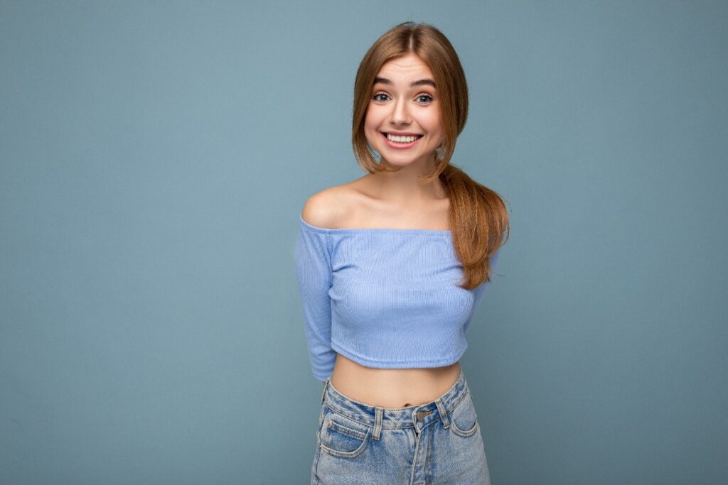 Une fille souriante portant un crop top de couleur bleu