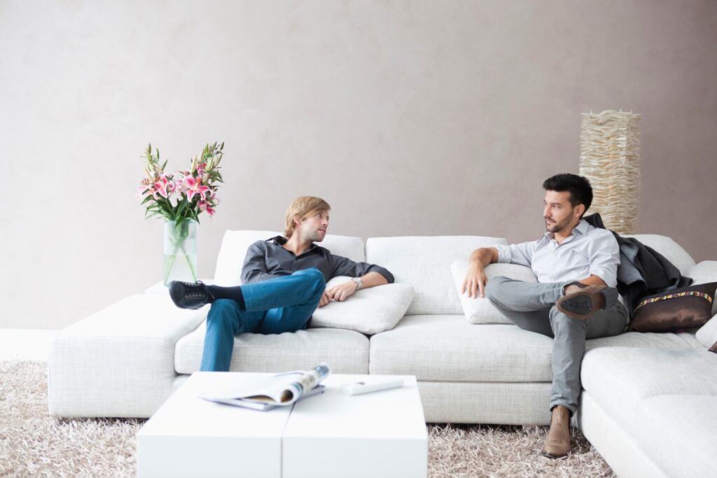 Des hommes qui discutent sur un canapé