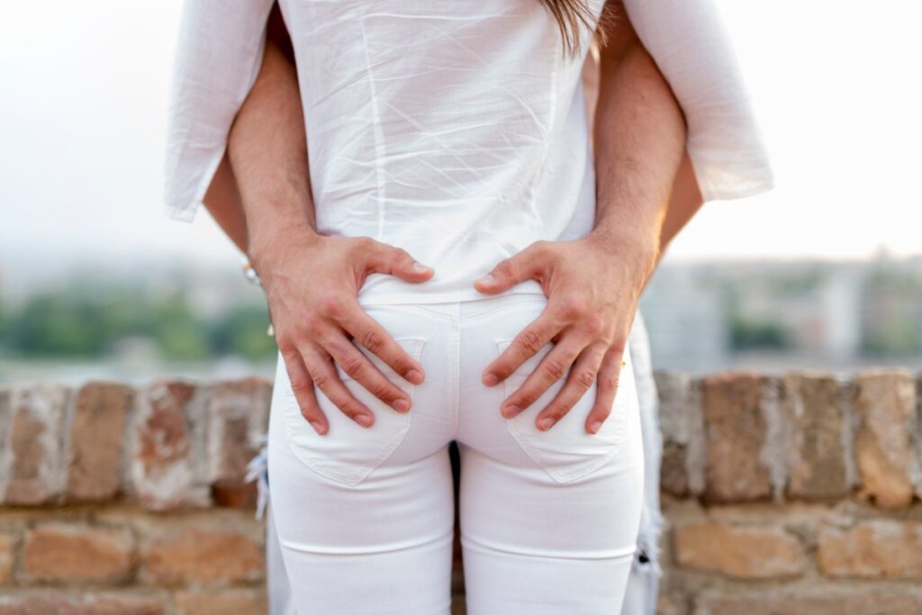 Mains d'un homme posées sur le bas du dos d'une femme