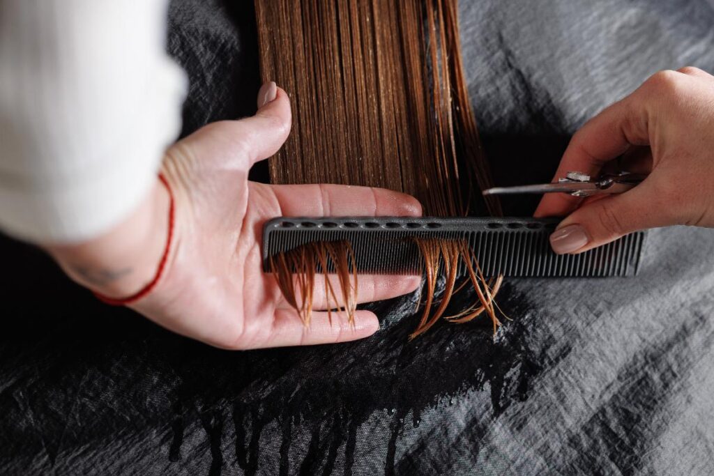 Une personne qui coupe les pointes du cheveux d'une femme