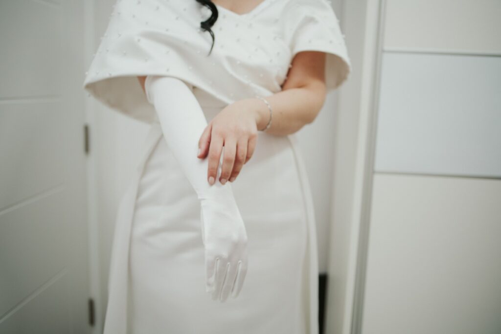 Une mariée en robe blanche avec une étole et un gant