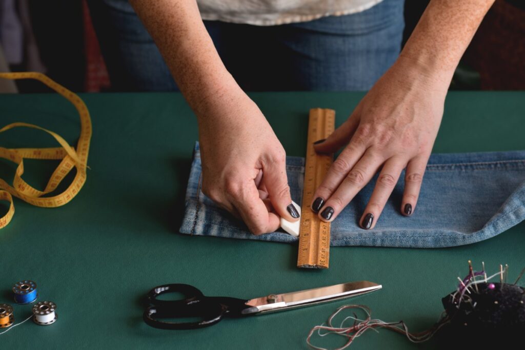 Une femme qui modifie la longueur d'un pantalon jean