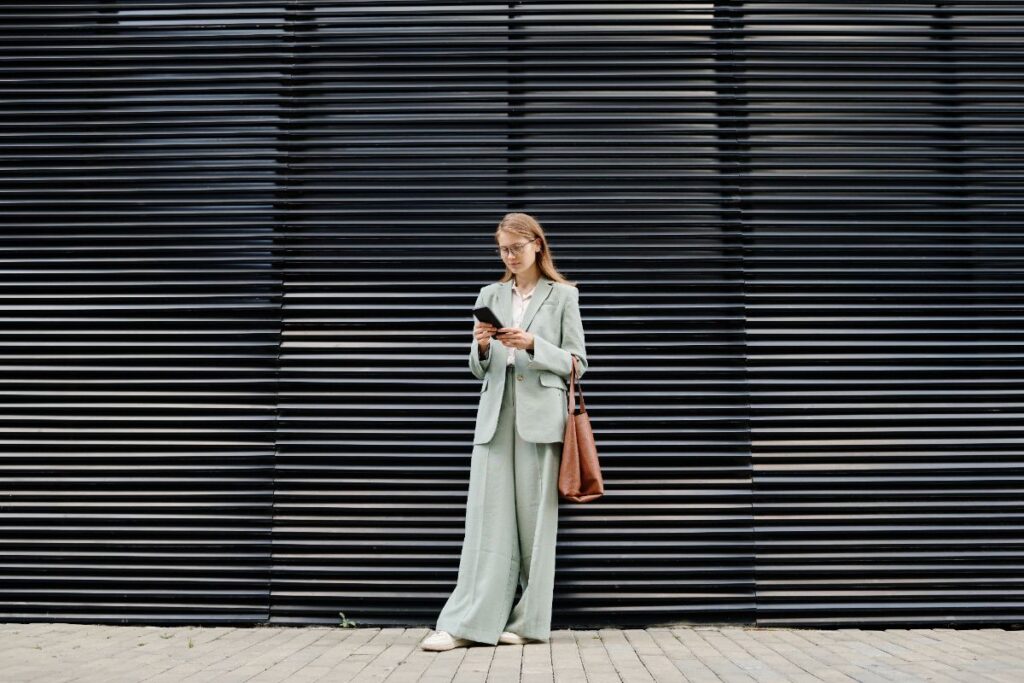 Une femme stylée debout en portant un ensemble vert et un tenis blanc