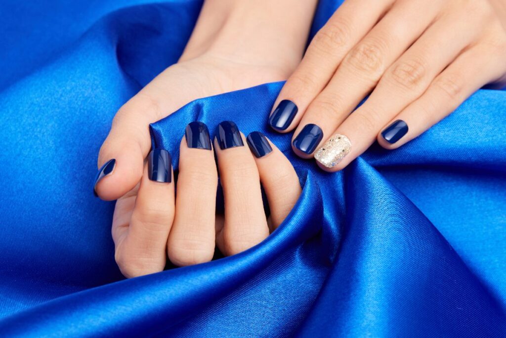 Mains d'une femme avec des ongles bleu