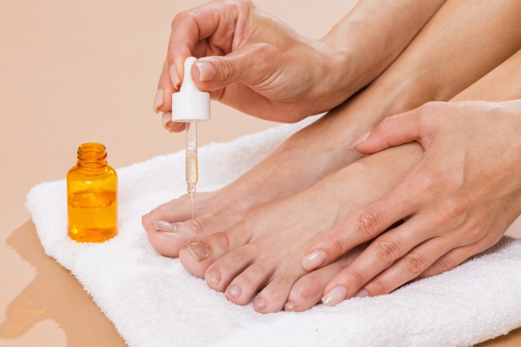 Une personne qui applique de l'huile sur les ongles 