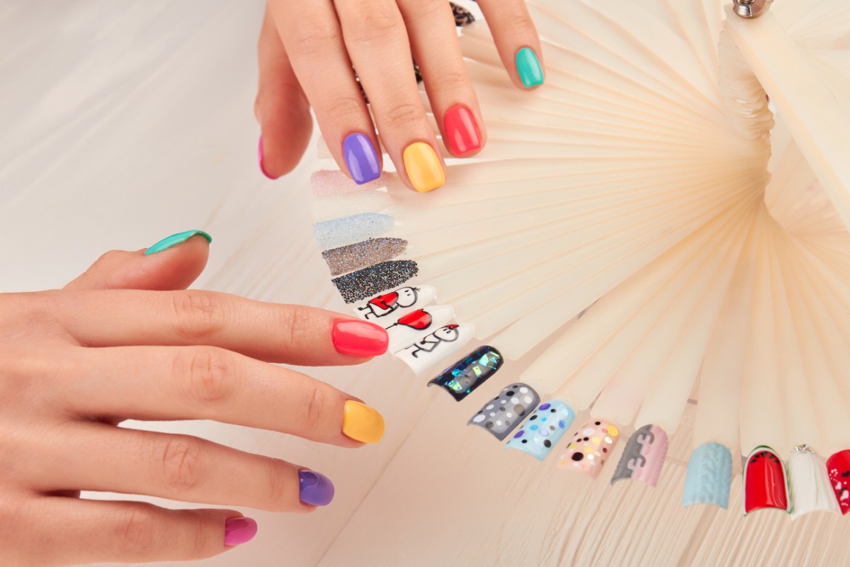 Une personne qui regarde des échantillons de vernis à ongles colorés