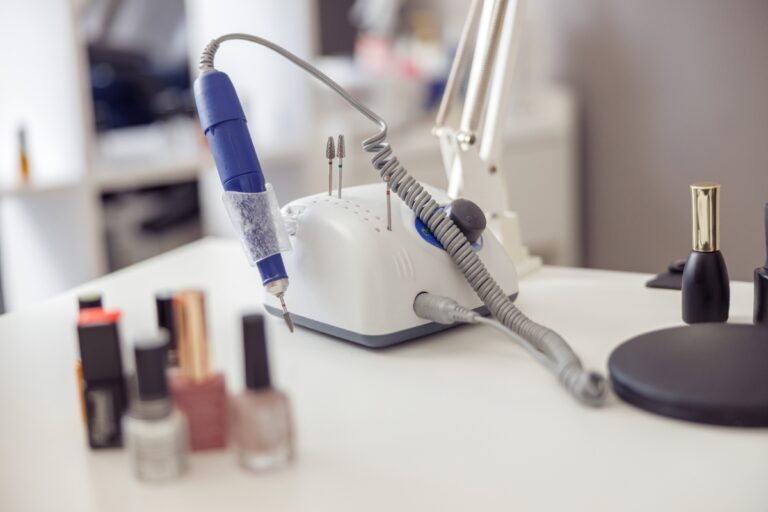 Une ponceuse professionnelle sur une table avec des vernis à ongles