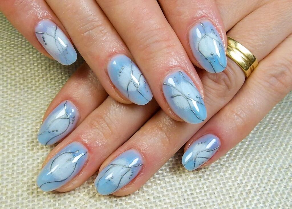 Mains avec de jolie manucure bleu à motif floral