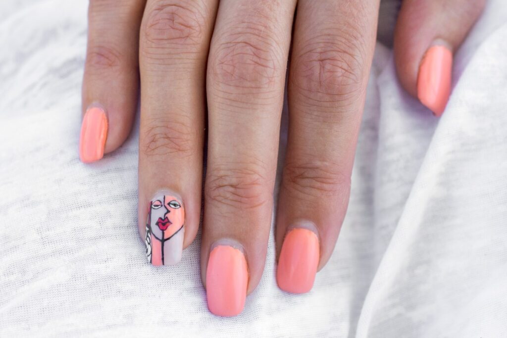 Main d'une femme avec du vernis à ongles artistiques