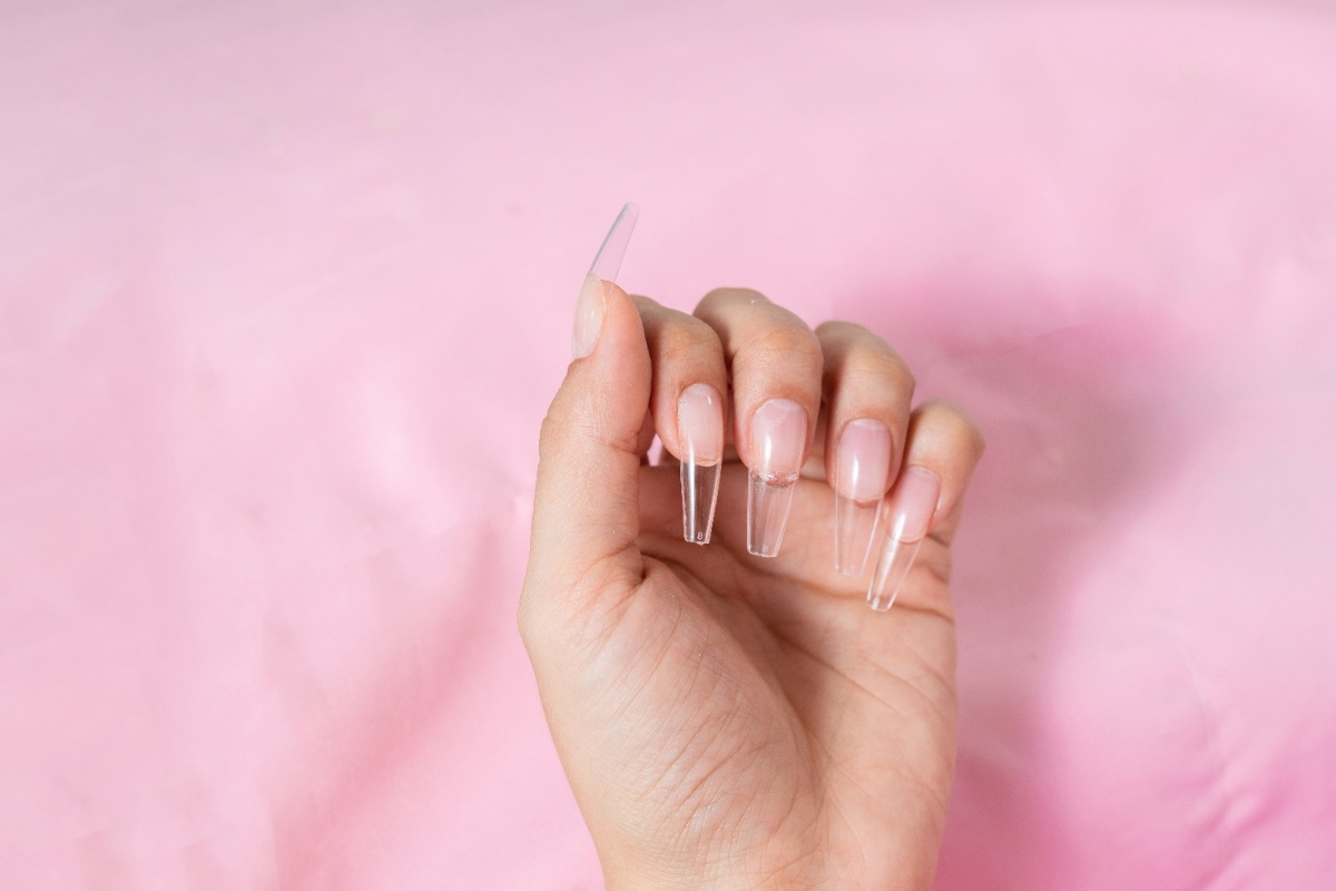 Main avec des longs ongles transparents