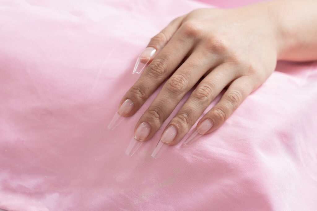 Main avec des ongles transparents acryliques