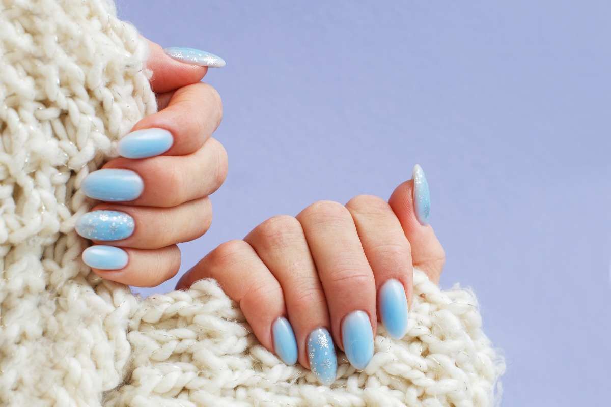 Mains avec du vernis à ongles bleu clair