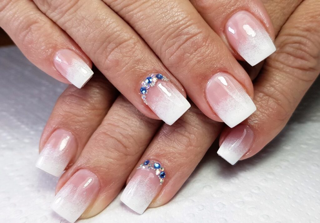 Mains avec du vernis semi-permanent babyboomer
