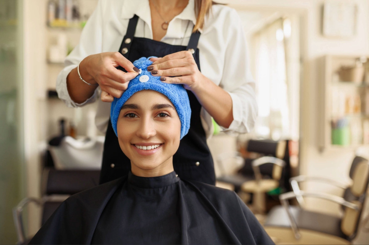 Une coiffeuse applique la charlotte cheveux sur la tête de sa cliente