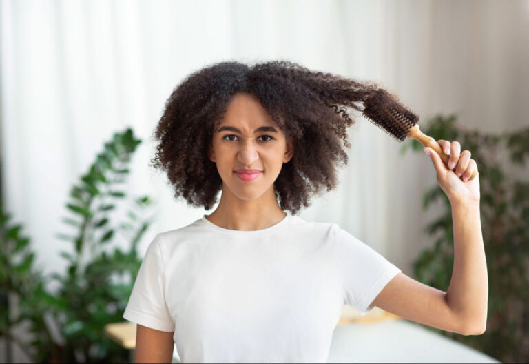 Une jolie femme applique des soins pour atténuer ses cheveux mousseux