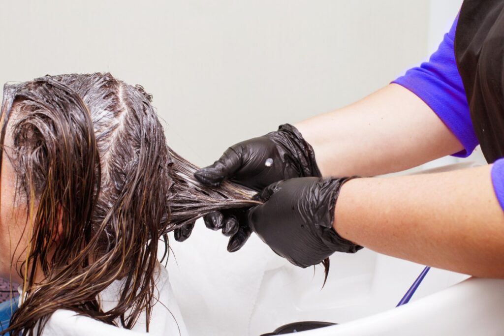 Un coiffeur appliquant de la teinture aux cheveux