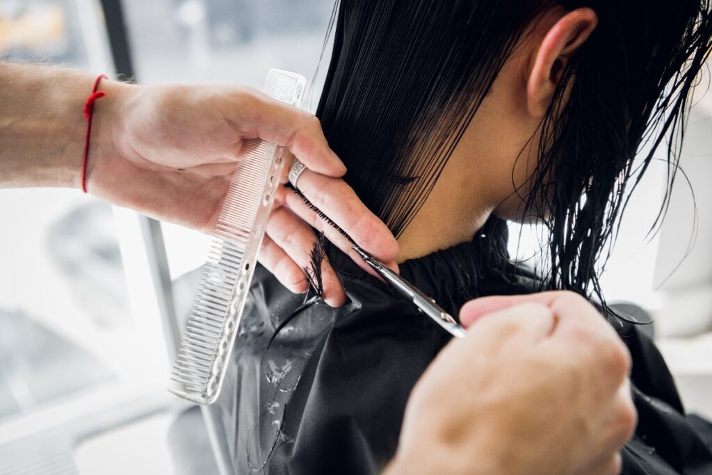 Un coiffeur coupant les cheveux d'une femme