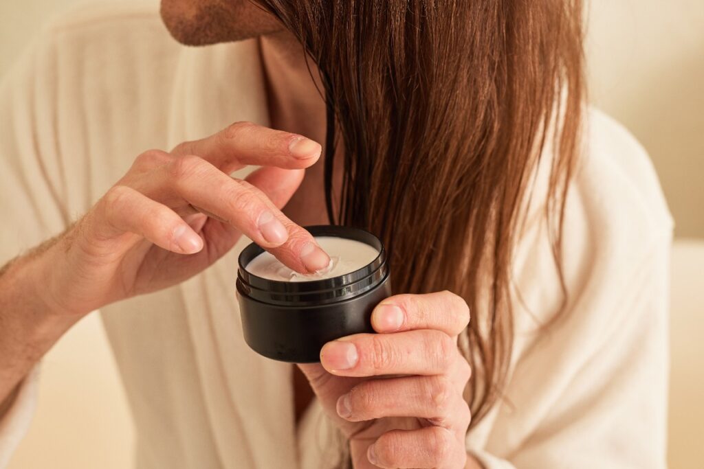 Une femme aux cheveux longs qui applique du masque 