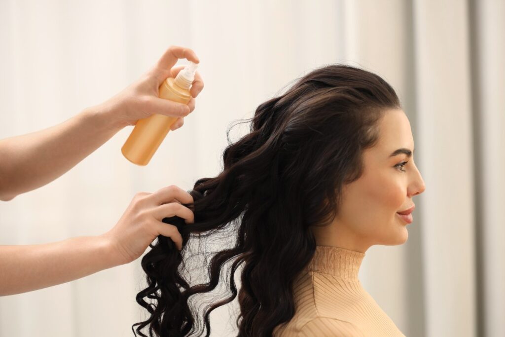 Une femme qui se fait coiffer ses cheveux bouclés dans un salon de coiffure