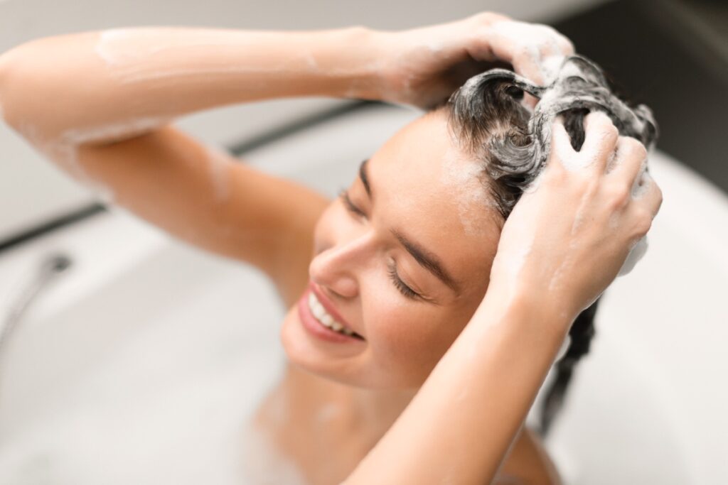 Une femme se lavant la tête couverte de shampooing