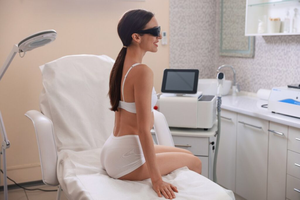 Une femme portant une lunette de soleil et assise dans un salon d'esthétique