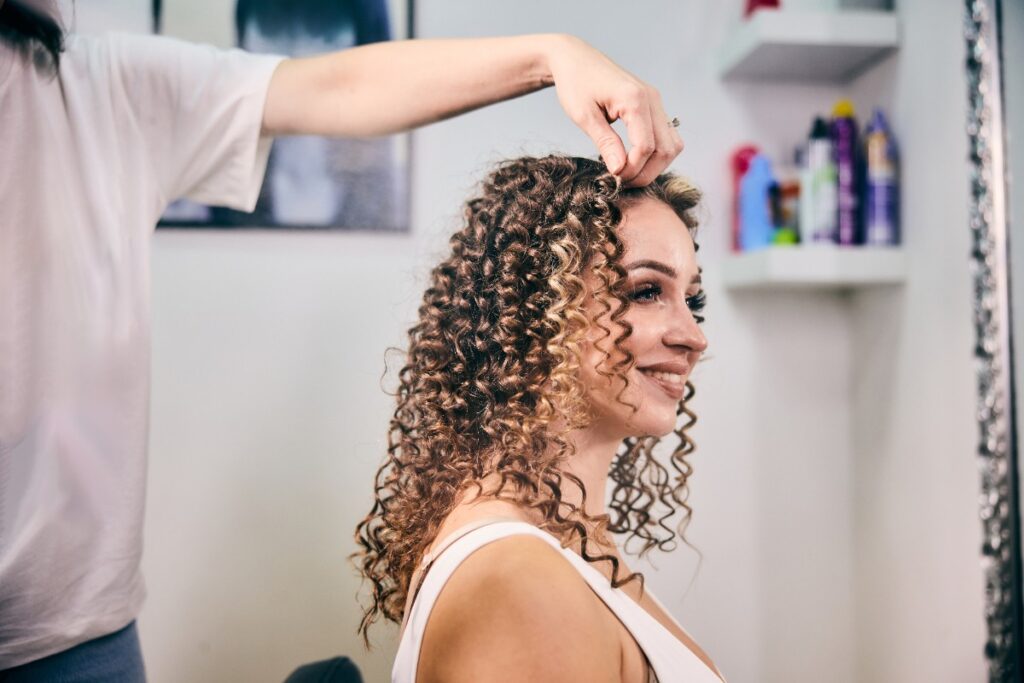 Une femme souriante avec des cheveux bouclés