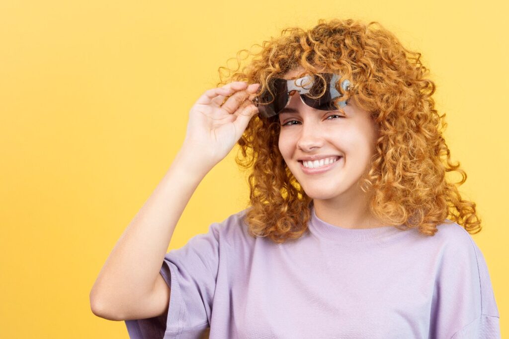 Une femme souriante mettant sa lunette